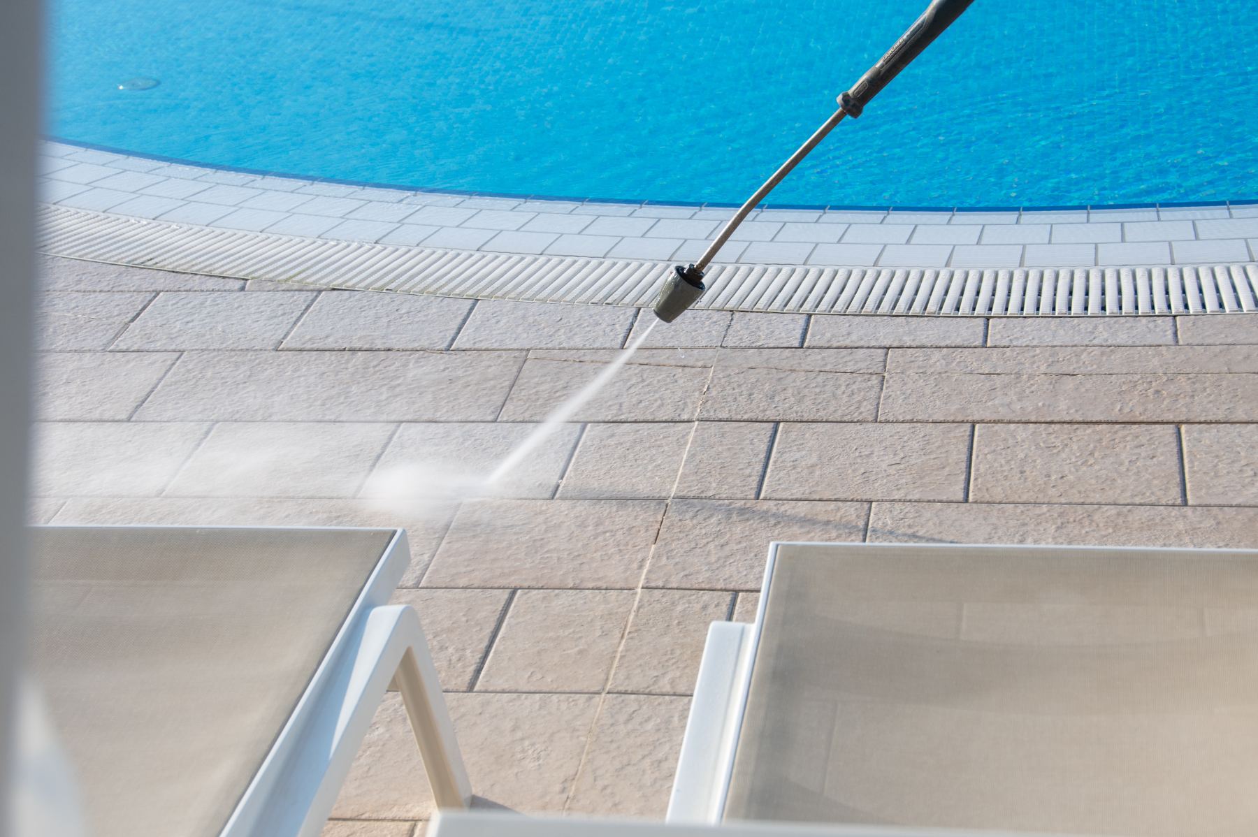 Power washing pool deck and pavement with high-pressure water spray